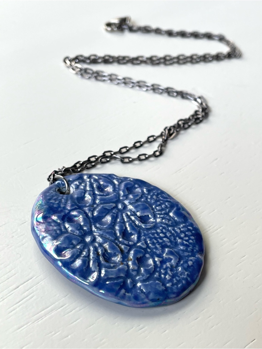 Pretty ceramic/porcelain pendant necklace w/ floral design & iridescence blue